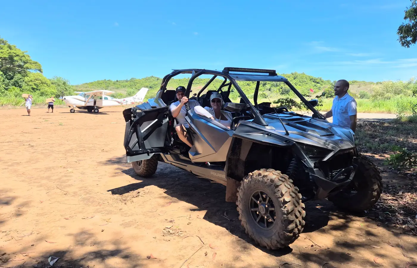 Buggy tout-terrain et petit avion charter sur une piste en terre à Madagascar