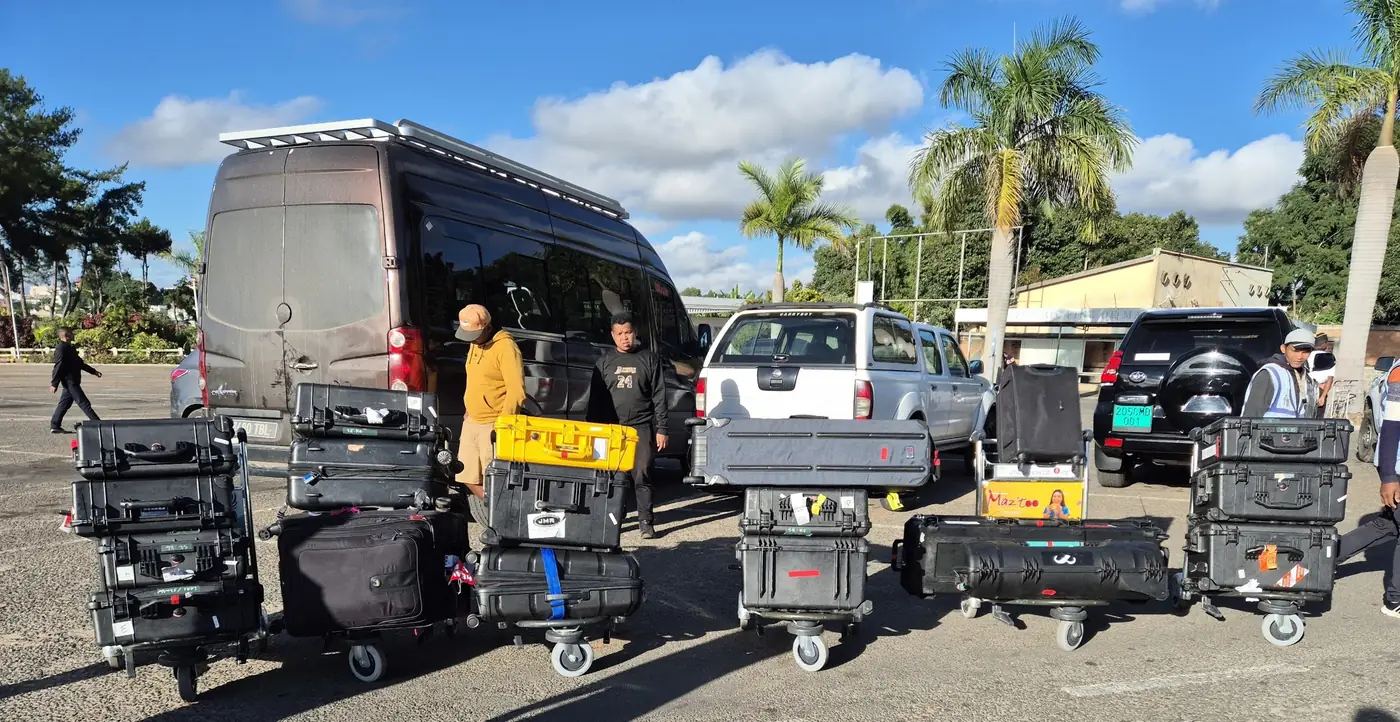 Trolleys of film equipment cases beside the crew vehicles at Ivato airport, Antananarivo