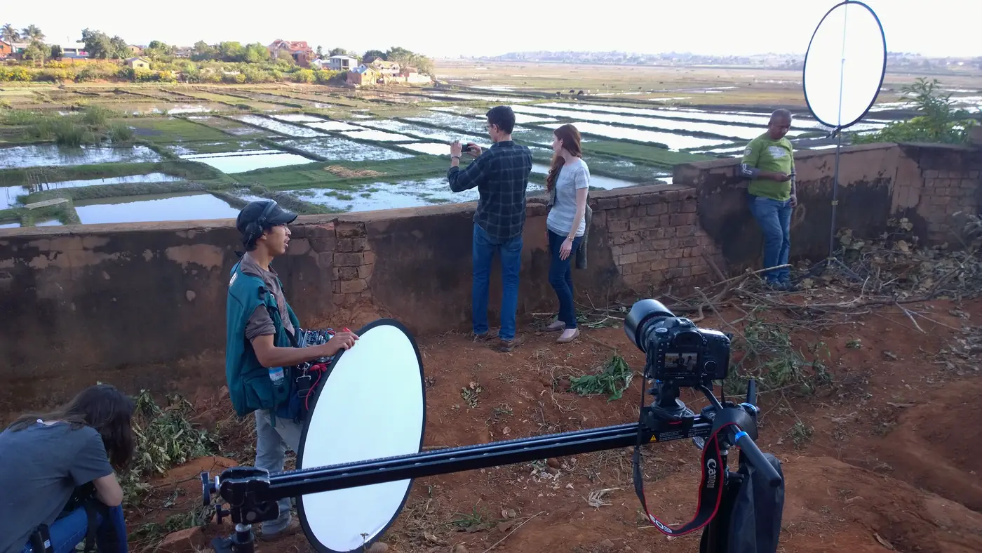 Crew member with a reflector on a shoot above rice fields near Antananarivo