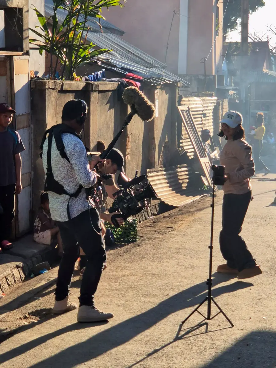 Local sound recordist and camera operator filming in a street of Antananarivo